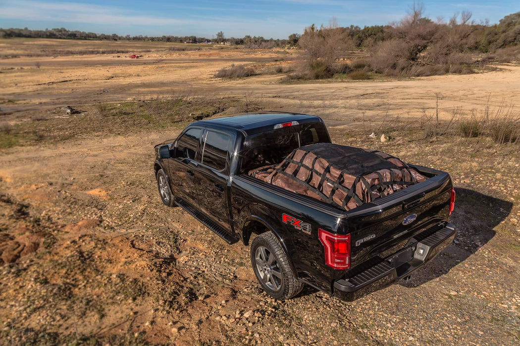 Cargo net with tarp out in field. Used for outdoor transporting goods in truck bed. 