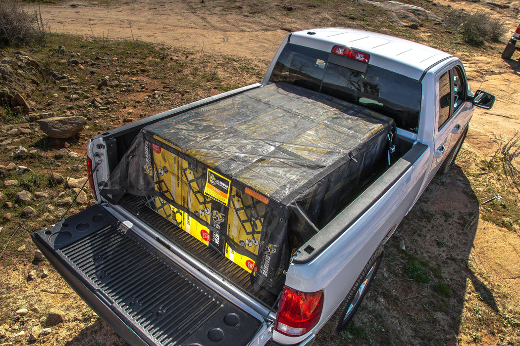 Mesh cargo tarp in truck bed. Rugged outdoor use. Used for camping gear.