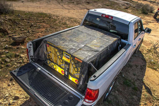 Mesh cargo tarp in truck bed. Rugged outdoor use. Used for camping gear.